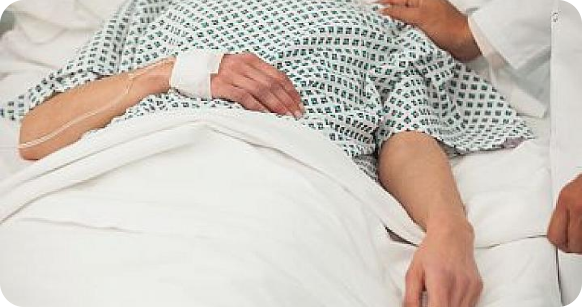 Patient laying down on a hospital bed with his hand connected to a machine