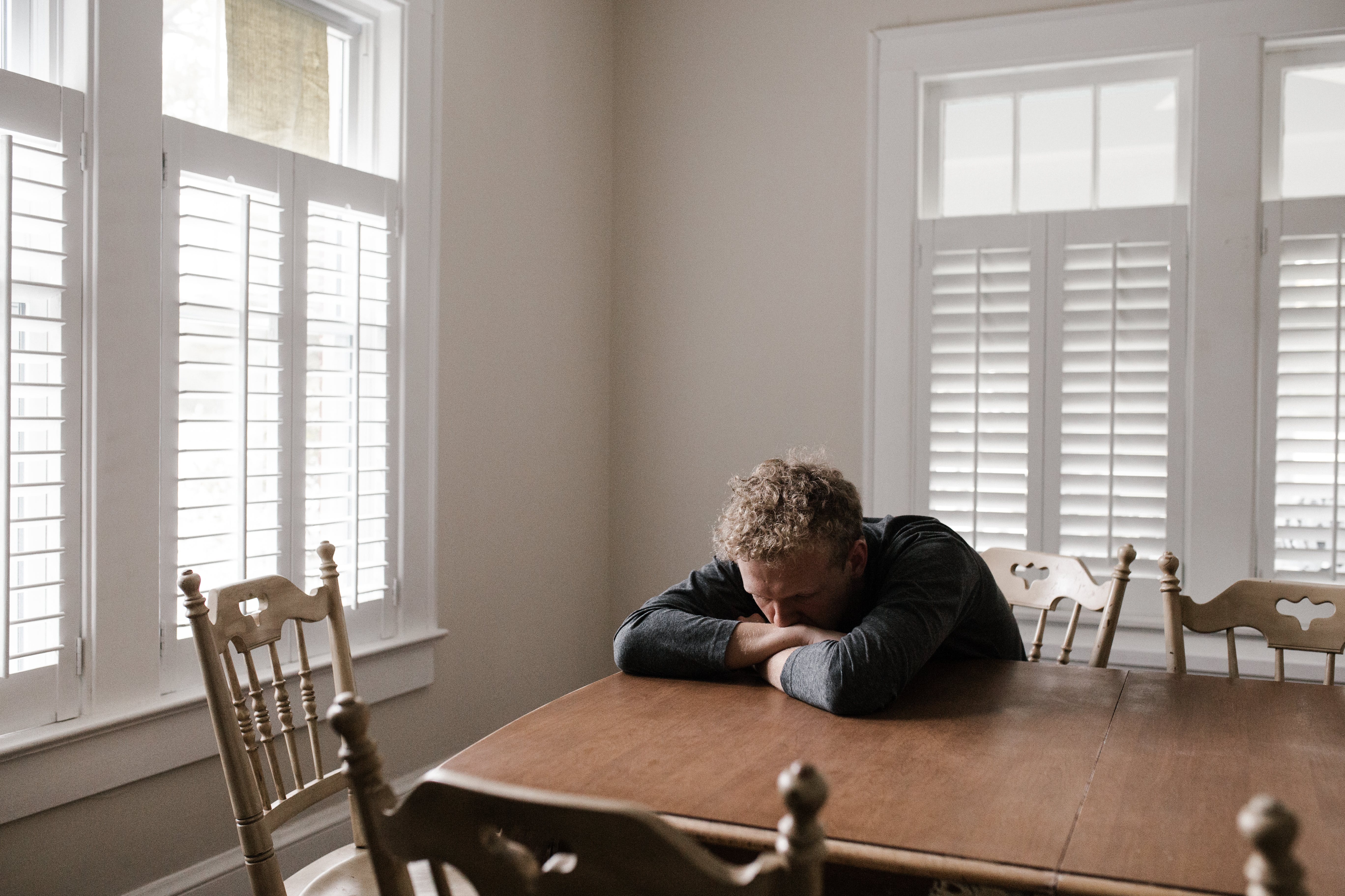 Sad man laying his head on a table